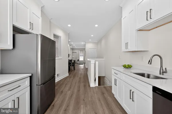 a kitchen with white cabinets and stainless steel appliances
