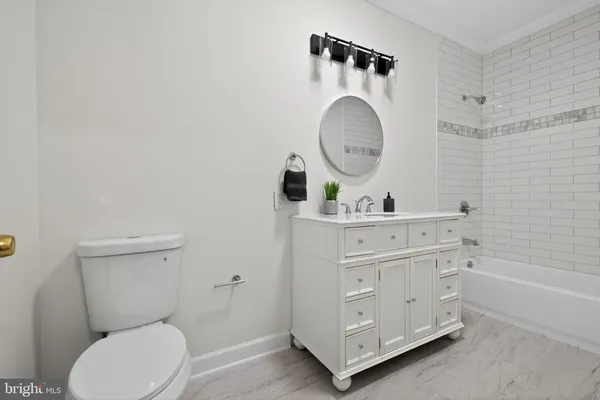 a bathroom with a toilet a sink a mirror and a bathtub