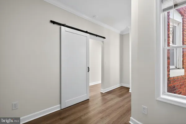 an empty room with wooden floor and a window