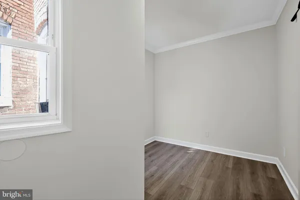 a view of a small space with wooden floor and a window