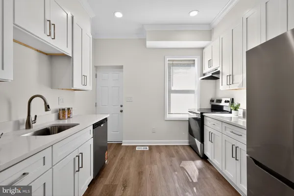 a kitchen with a sink cabinets stainless steel appliances and a window