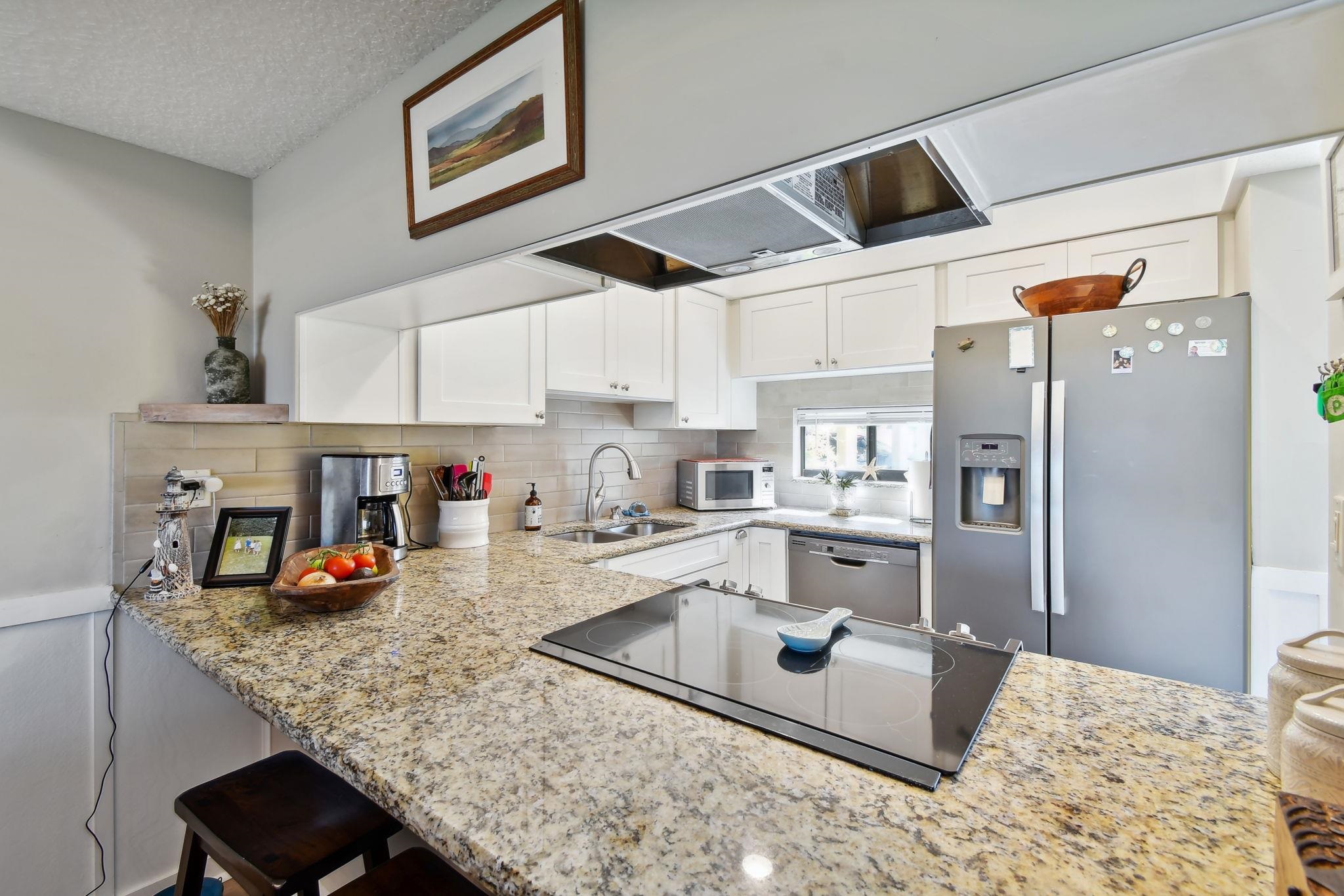 131 Rio Del Mar Street, Unit E St. Augustine, FL 32080 - Photo 15 of 67 a kitchen with stainless steel appliances granite countertop a sink refrigerator and microwave