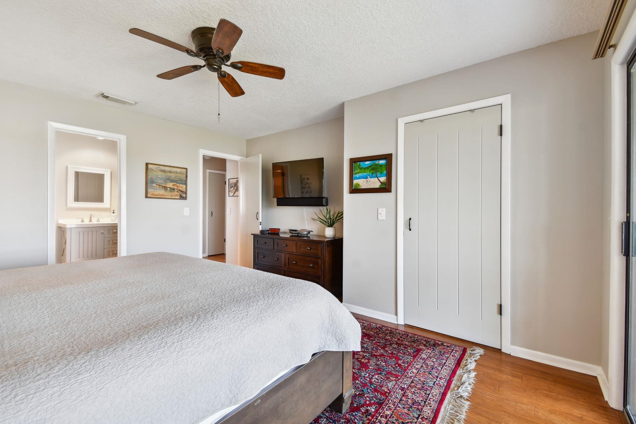 131 Rio Del Mar Street, Unit E St. Augustine, FL 32080 - Photo 35 of 67 a bedroom with a bed and a chandelier