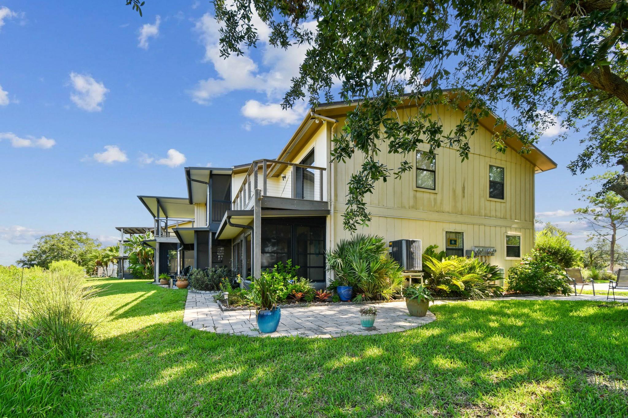 131 Rio Del Mar Street, Unit E St. Augustine, FL 32080 - Photo 42 of 67 a front view of a house with a yard and potted plants