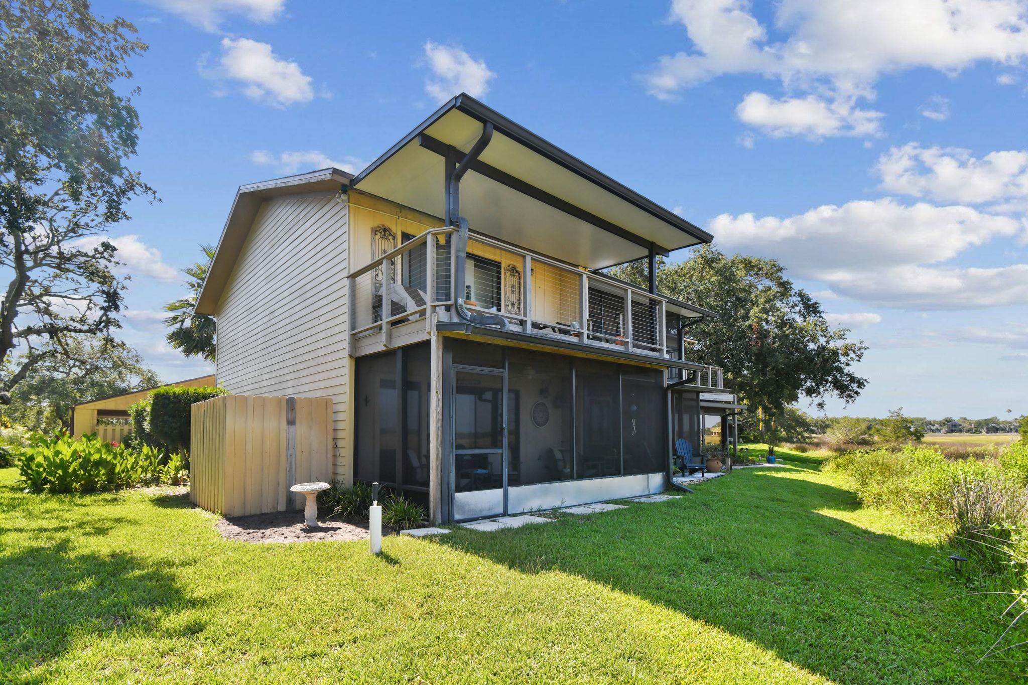 131 Rio Del Mar Street, Unit E St. Augustine, FL 32080 - Photo 43 of 67 a backyard of a house with wooden fence and a large tree
