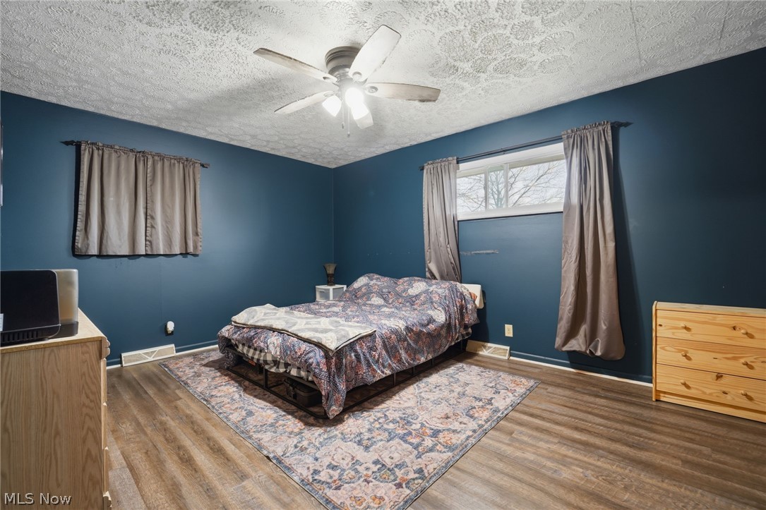 14557 Ellsworth Road Berlin Center, OH 44401 - Photo 12 of 23 Bedroom with wood finished floors, ceiling fan, and a textured ceiling