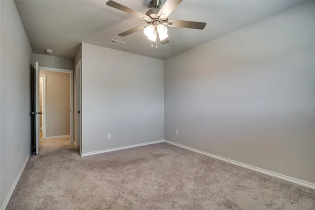 an empty room with closet and a chandelier fan