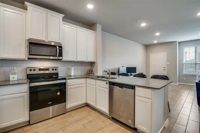 a kitchen with granite countertop a stove sink and cabinets