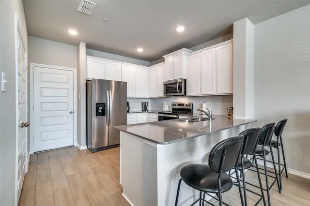 a kitchen with kitchen island a refrigerator stove microwave and cabinets