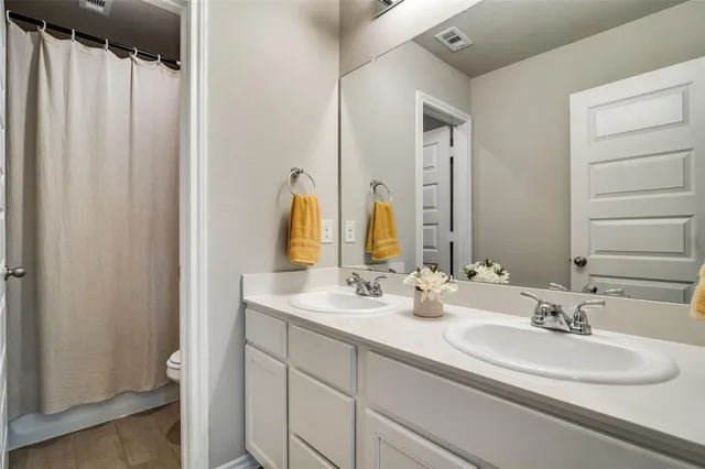a bathroom with double vanity sinks and a mirror