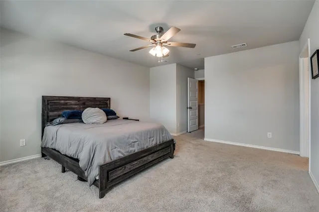 a bedroom with a bed and a ceiling fan