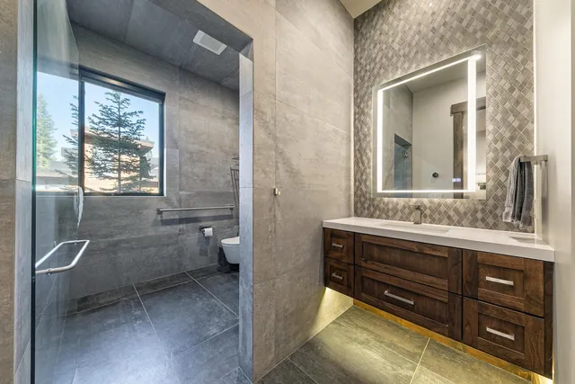 a bathroom with a granite countertop sink toilet and shower