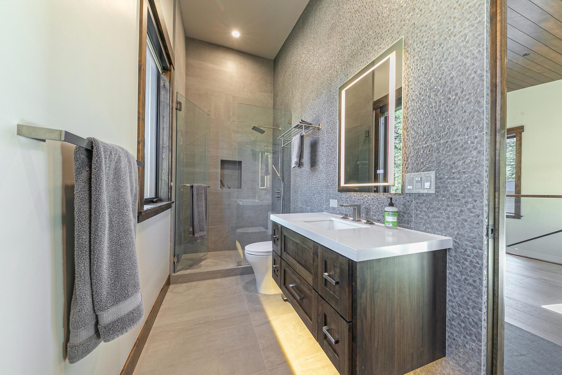 10645 Carson Range Road Truckee, CA 96161 - Photo 21 of 28 a bathroom with a sink a large mirror and a shower