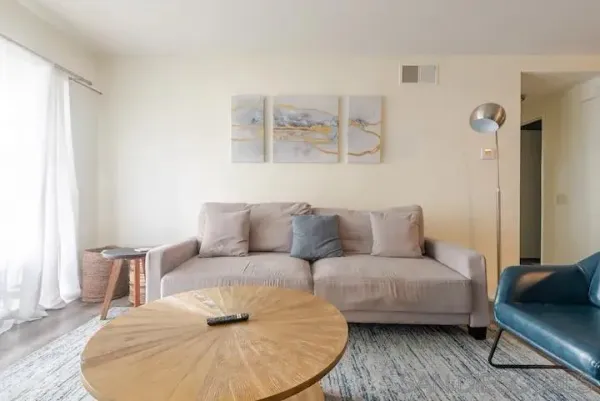 a living room with furniture and a wooden floor