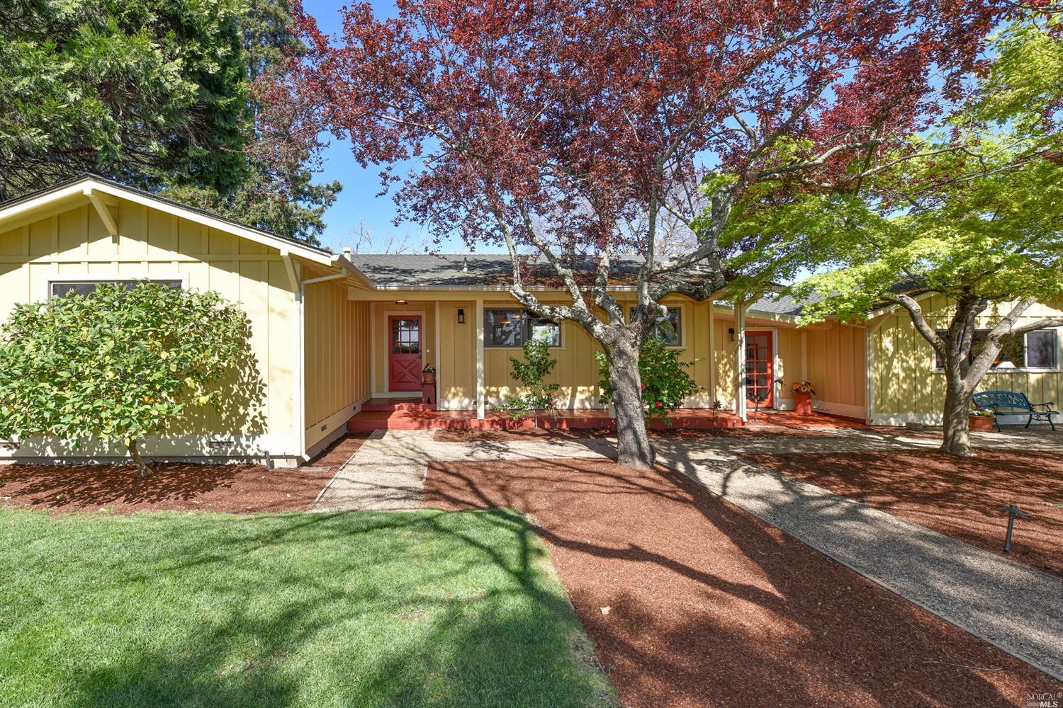 a view of a house with backyard and trees