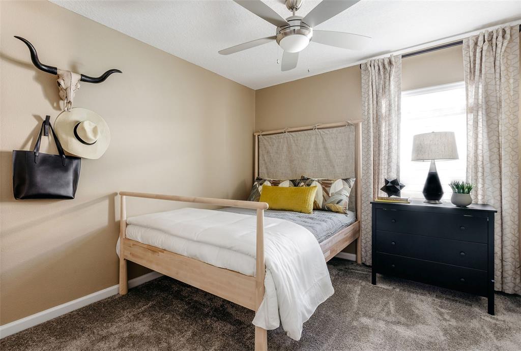 2011 Myrtle Pine Street Kissimmee, FL 34746 - Photo 15 of 28 a bedroom with a bed and a chandelier