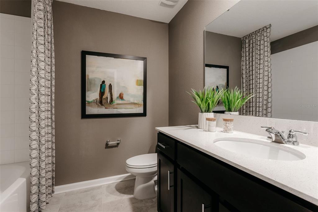 2011 Myrtle Pine Street Kissimmee, FL 34746 - Photo 16 of 28 a bathroom with a granite countertop sink toilet and a mirror