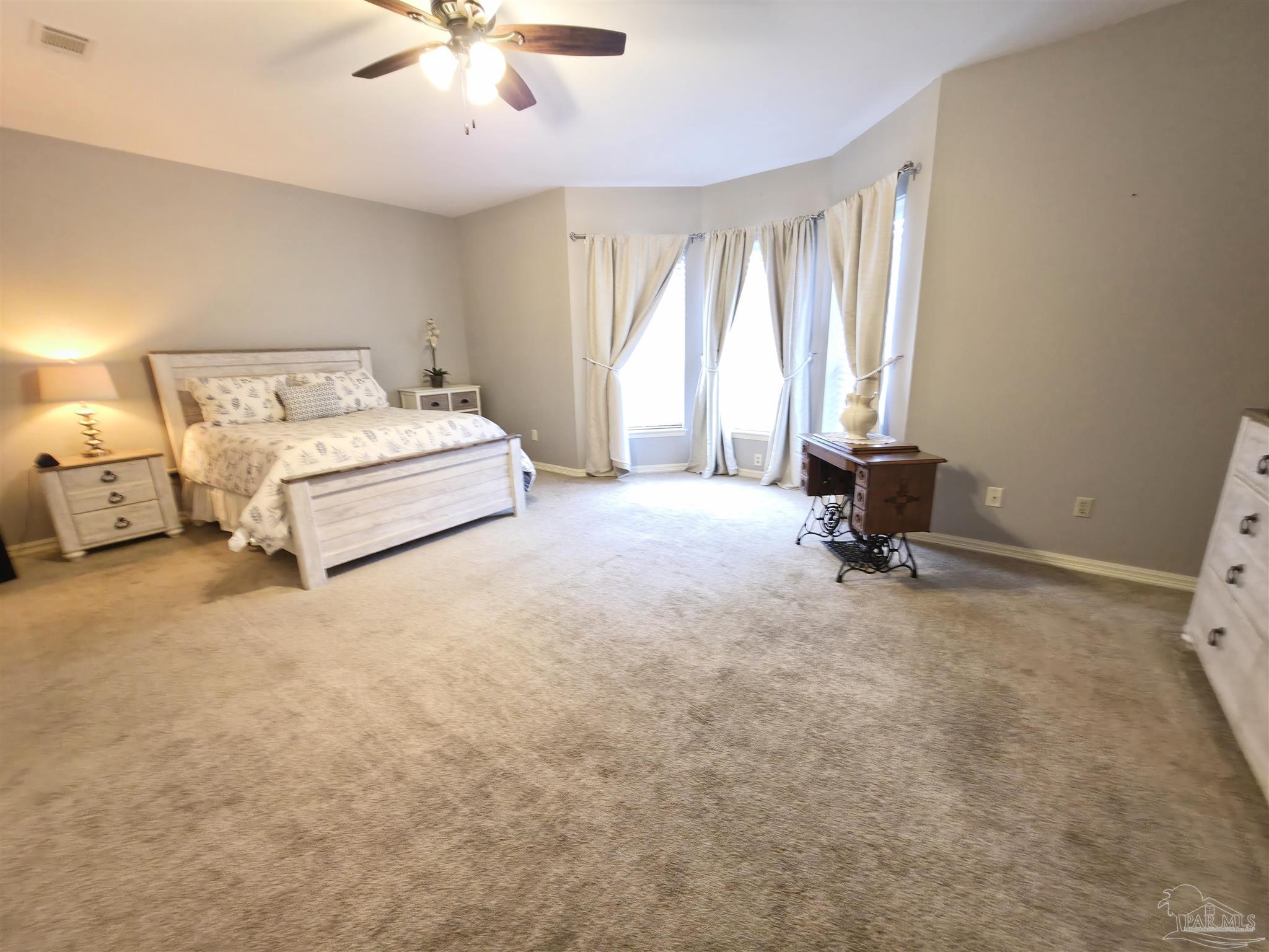 3249 Windmill Circle Cantonment, FL 32533 - Photo 29 of 44 a spacious bedroom with a bed and a chandelier