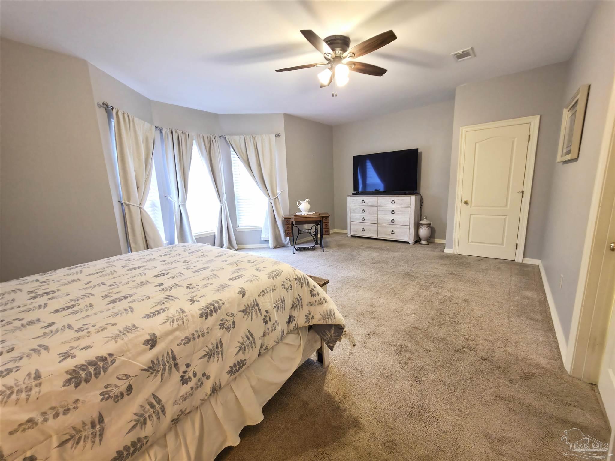 3249 Windmill Circle Cantonment, FL 32533 - Photo 30 of 44 a spacious bedroom with a bed and a flat screen tv