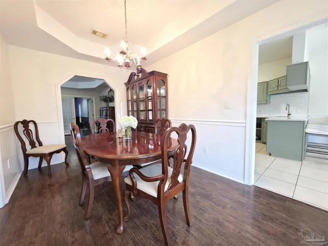 a kitchen with stainless steel appliances a sink counter space and chairs