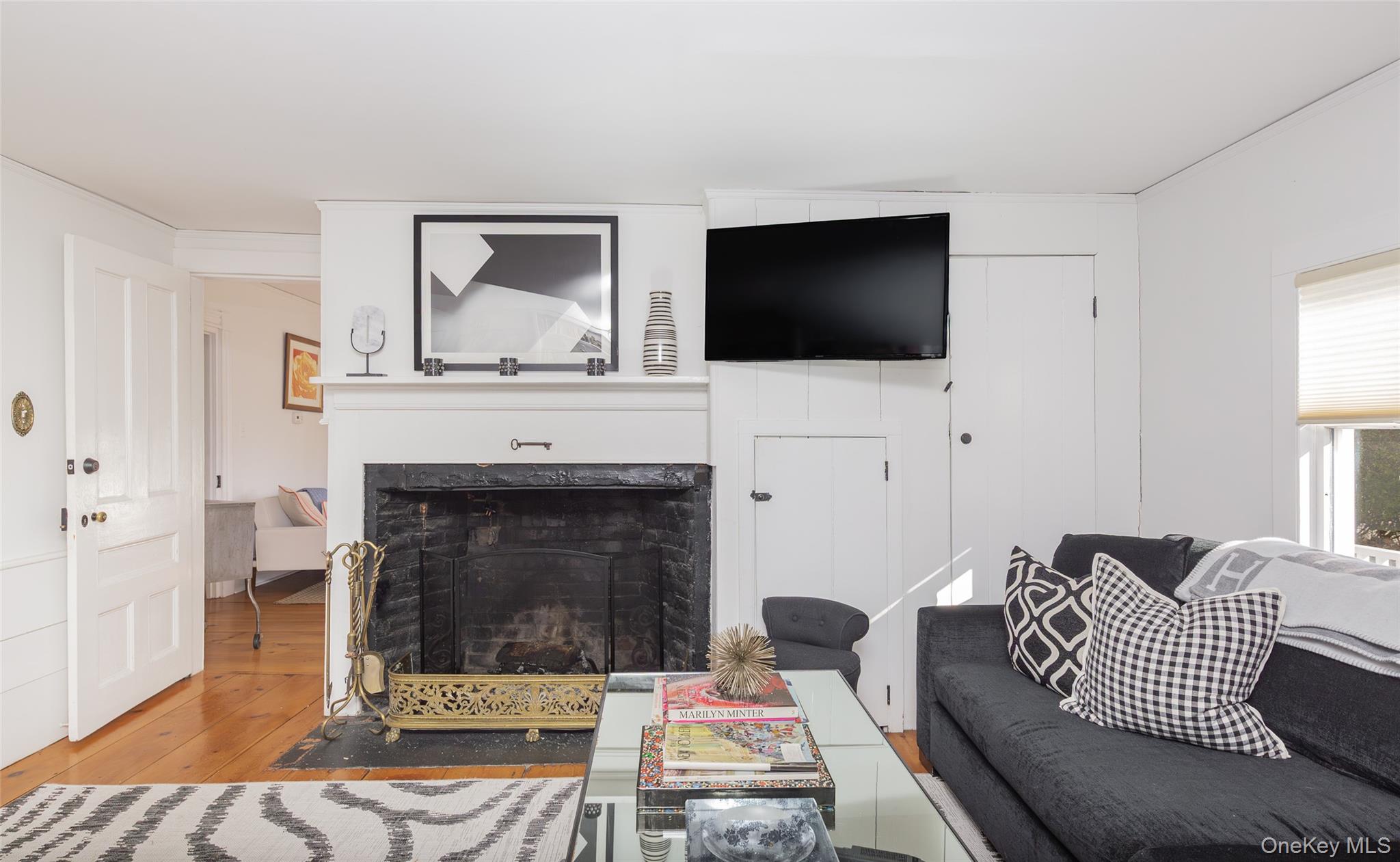 78 Mecox Road Water Mill, NY 11976 - Photo 18 of 41 a living room with furniture a flat screen tv and a fireplace