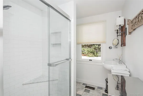 a bathroom with a shower sink and mirror