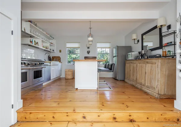 a living room with stainless steel appliances kitchen island granite countertop a stove and a refrigerator