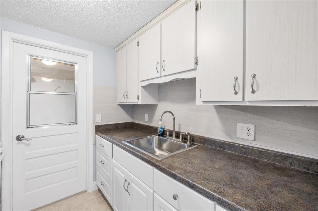 4948 Getner Street New Port Richey, FL 34652 - Photo 11 of 20 a kitchen with granite countertop white cabinets and sink