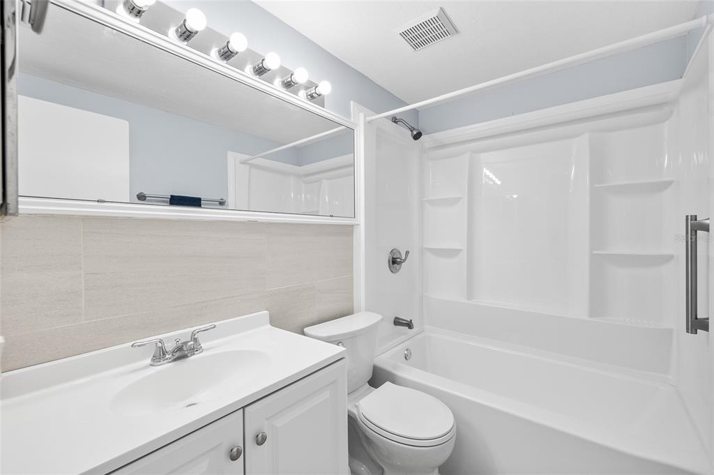 4948 Getner Street New Port Richey, FL 34652 - Photo 14 of 20 a bathroom with a sink mirror toilet and bathtub