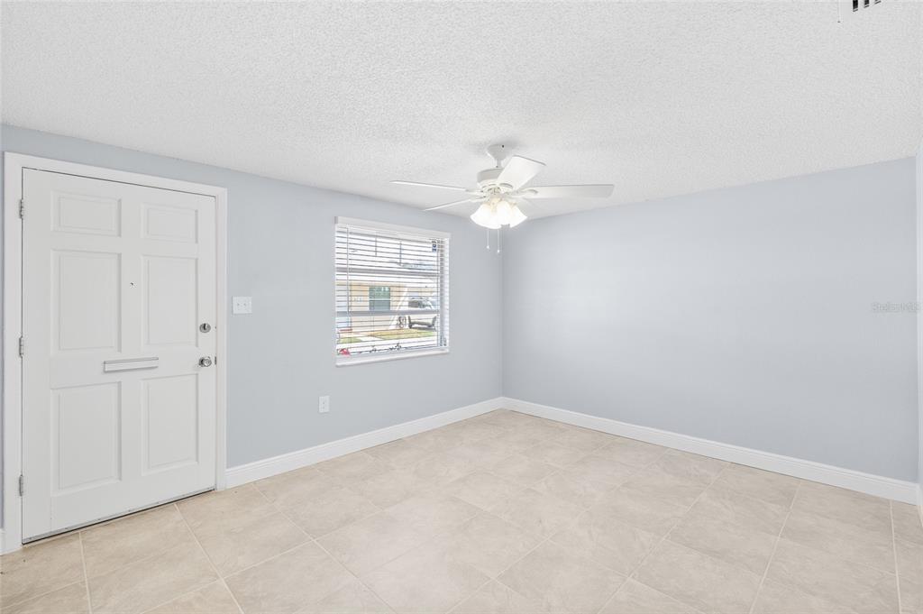 4948 Getner Street New Port Richey, FL 34652 - Photo 4 of 20 an empty room with windows and chandelier fan