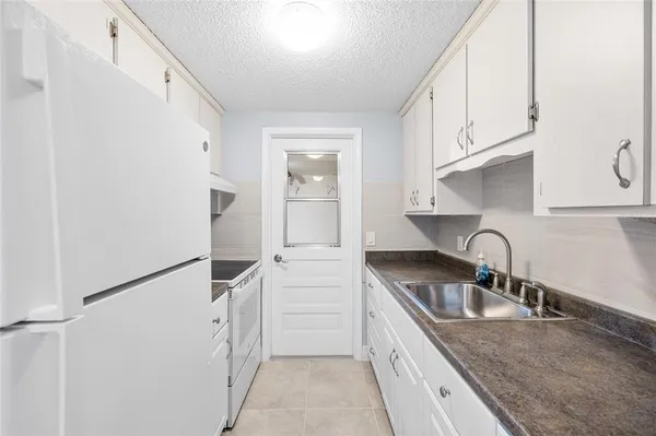 a kitchen with white cabinets and white appliances