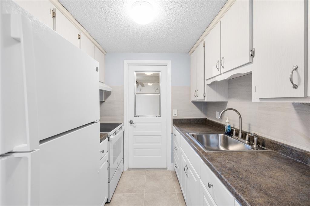 4948 Getner Street New Port Richey, FL 34652 - Photo 9 of 20 a kitchen with granite countertop a sink stainless steel appliances and cabinets