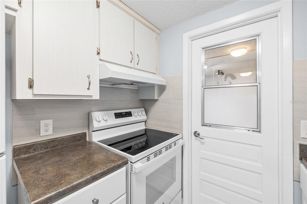 4948 Getner Street New Port Richey, FL 34652 - Photo 10 of 20 a kitchen with white cabinets and white appliances