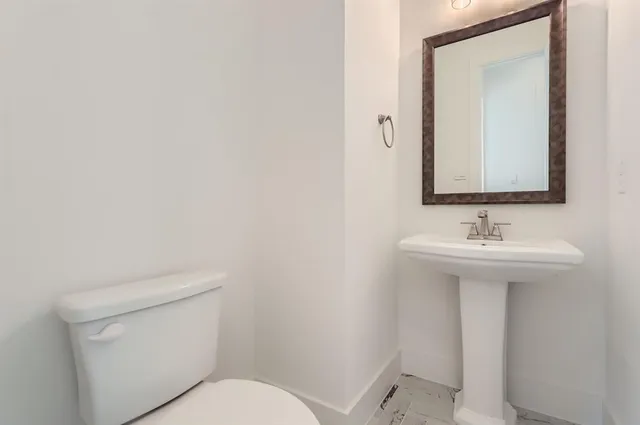 a bathroom with a sink a toilet and mirror