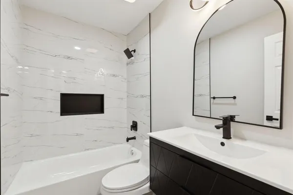 a bathroom with a sink a toilet a mirror and shower