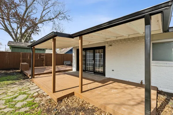 a backyard of a house with table and chairs
