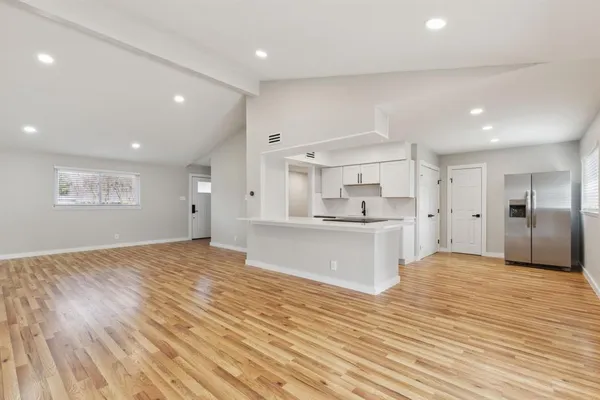 a view of kitchen with kitchen island granite countertop cabinets and wooden floor