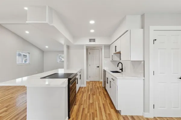a kitchen with stainless steel appliances a refrigerator sink and white cabinets