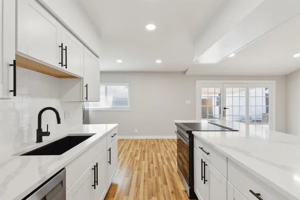 a kitchen with a sink a stove and cabinets