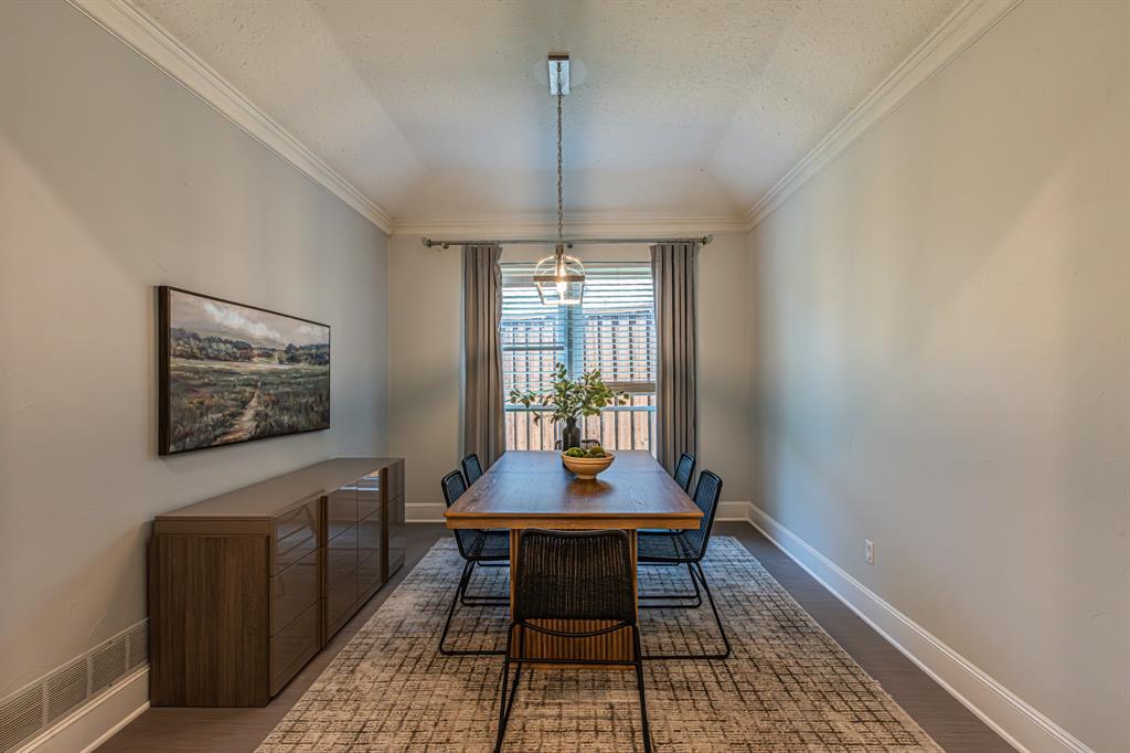 300 Sundance Circle Irving, TX 75063 - Photo 18 of 39 Dining area featuring wood-finish flooring, crown molding, a modern pendant light fixture, and a window with blinds and drapes