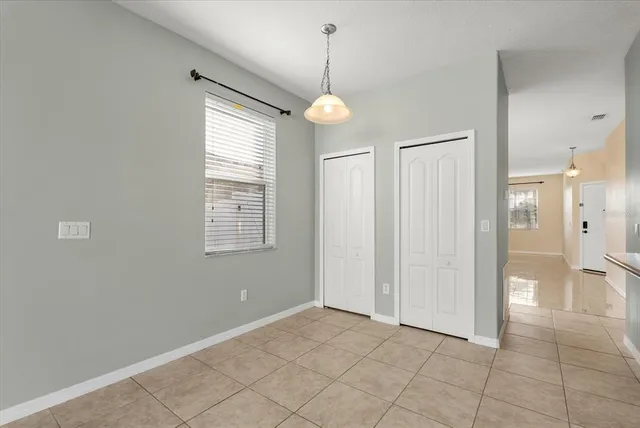 a view of an empty room with cabinet and a chandelier