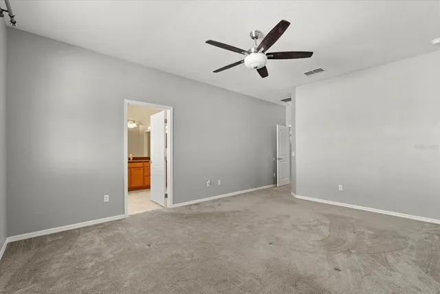 an empty room with closet and fan