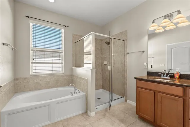 a bathroom with a tub a sink and a mirror