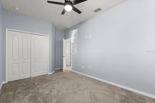 an empty room with a ceiling fan and a window