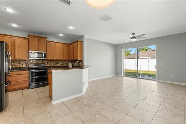 a kitchen with granite countertop a stove cabinets and refrigerator