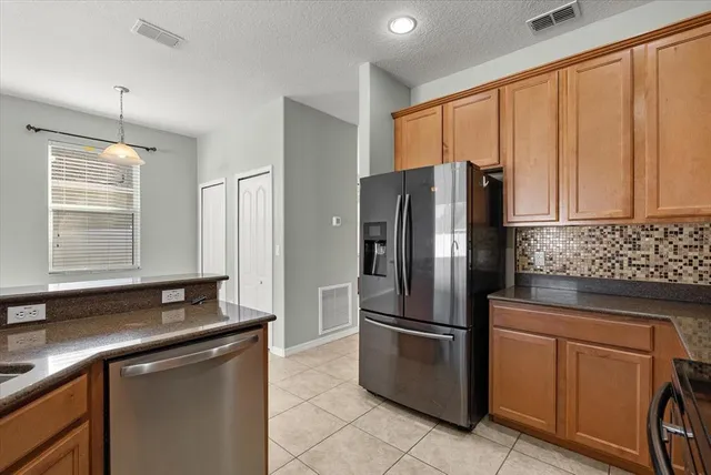 a kitchen with stainless steel appliances granite countertop a refrigerator and a sink
