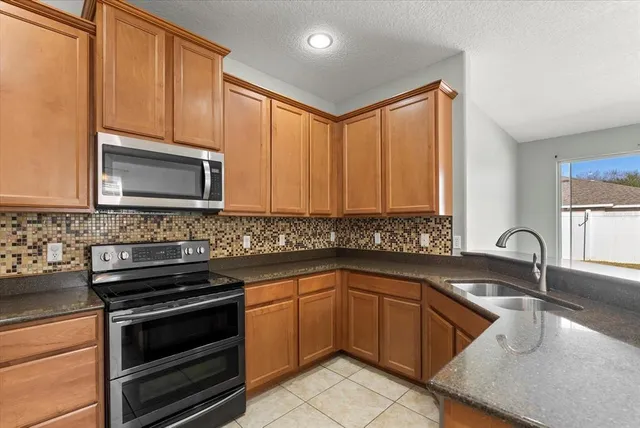 a kitchen with a sink stove and microwave
