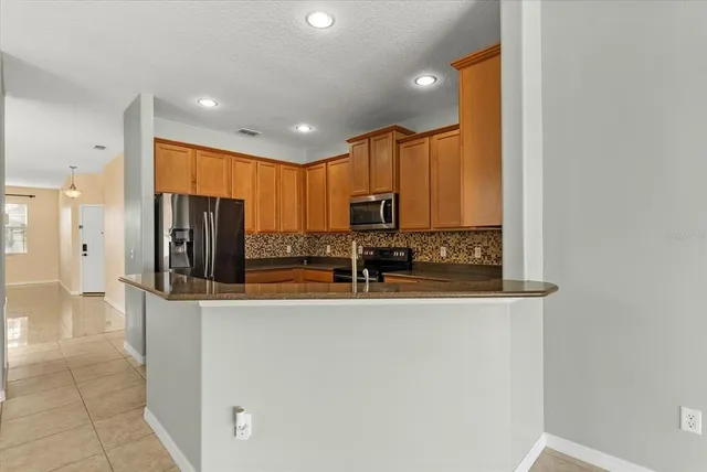 a kitchen with stainless steel appliances granite countertop a refrigerator and a sink