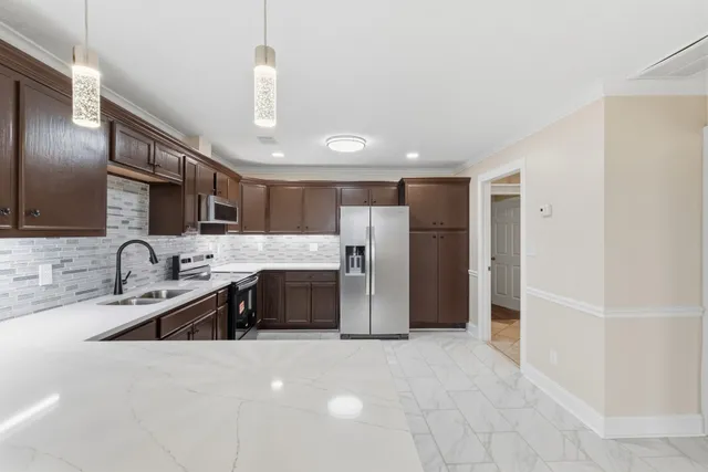 a view of an empty room with wooden floor and a ceiling fan