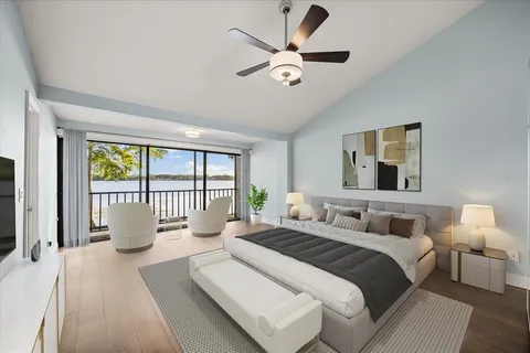 a kitchen with stainless steel appliances kitchen island a refrigerator a stove a sink and white cabinets with wooden floor